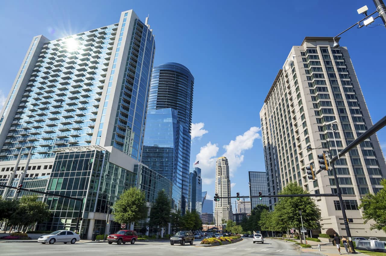 Modern luxury high-rise buildings in Lenox/Buckhead Heights, GA with glass facades, balconies, and tree-lined streets.
